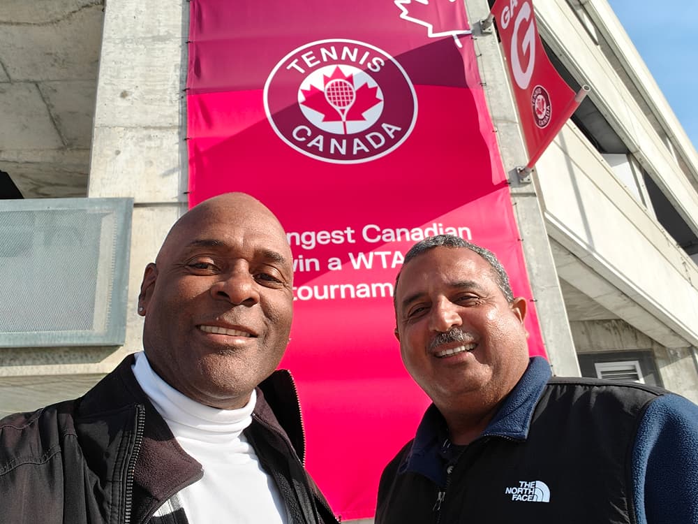 Kevin Ware posing with another attendee in front of a Tennis Canada banner.